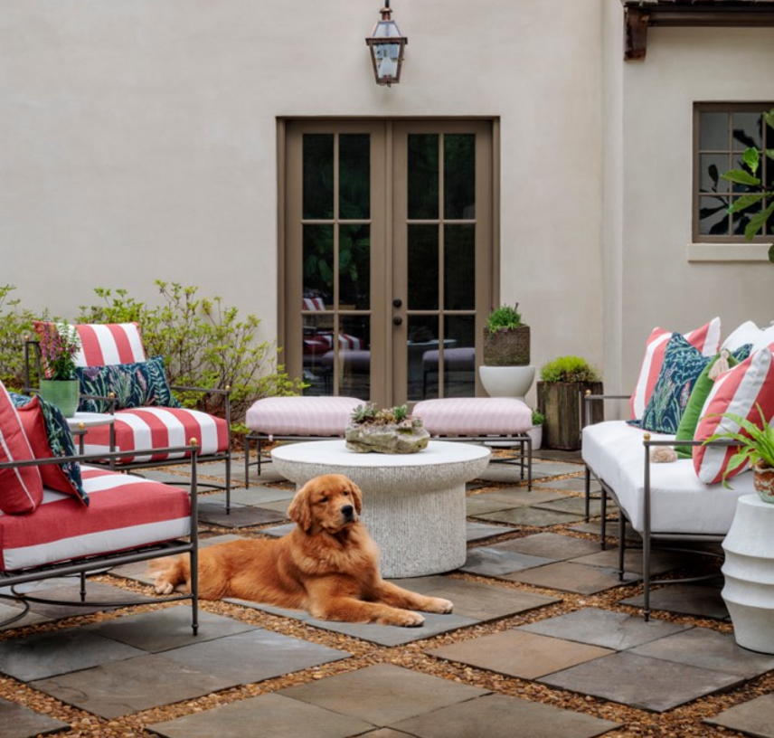 Outdoor patio with dog and outdoor furniture with vibrant red stripes