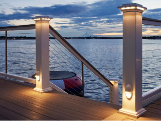 Cable deck railing with low-voltage accent lighting from TimberTech, overlooking waterfront scene at sunset
