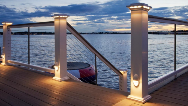 Cable deck railing with low-voltage accent lighting from TimberTech, overlooking waterfront scene at sunset