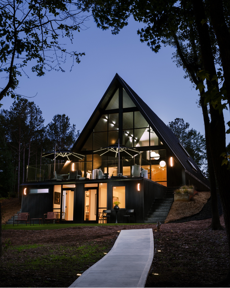 Rear exterior at night showing home lit from within and a walkway that leads down to a dock on Lake Hartwell, GA