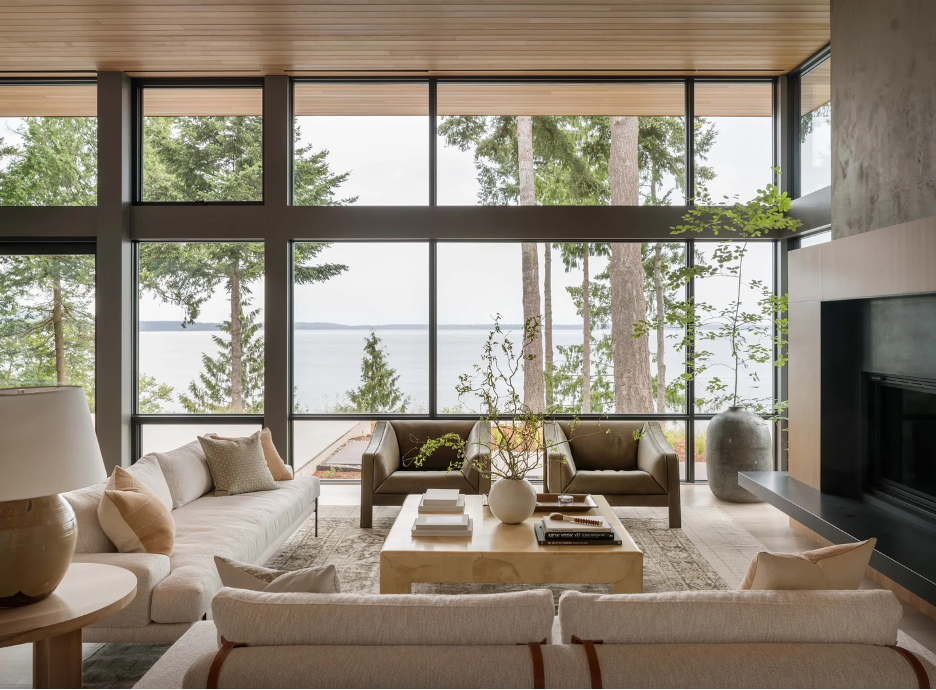 layering of beautiful neutral textures in a Scandinavian-style lake home living room with beautiful trees and lake in the background