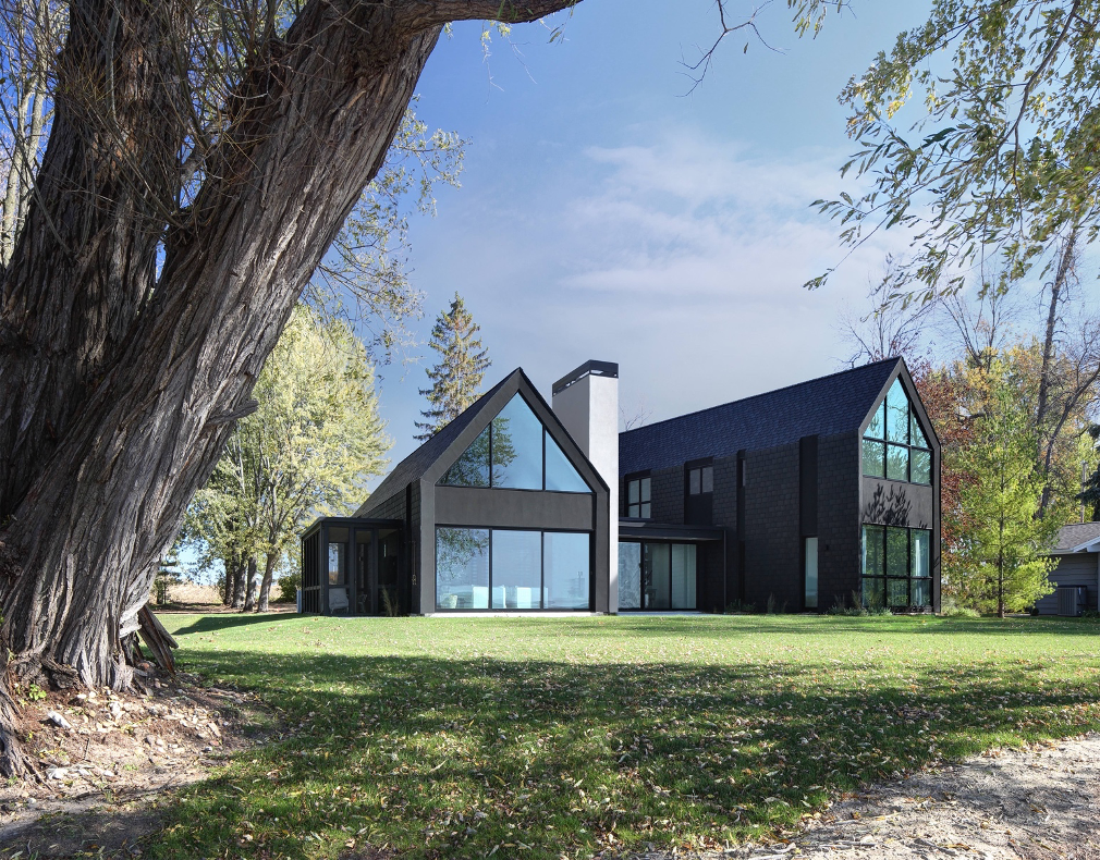 Exterior facing the lake: Two bold gabled forms instill the fundamental vision of a home while the central vestibule quietly connects them.