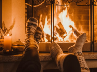cozy socks in feet in front of a roaring fireplace