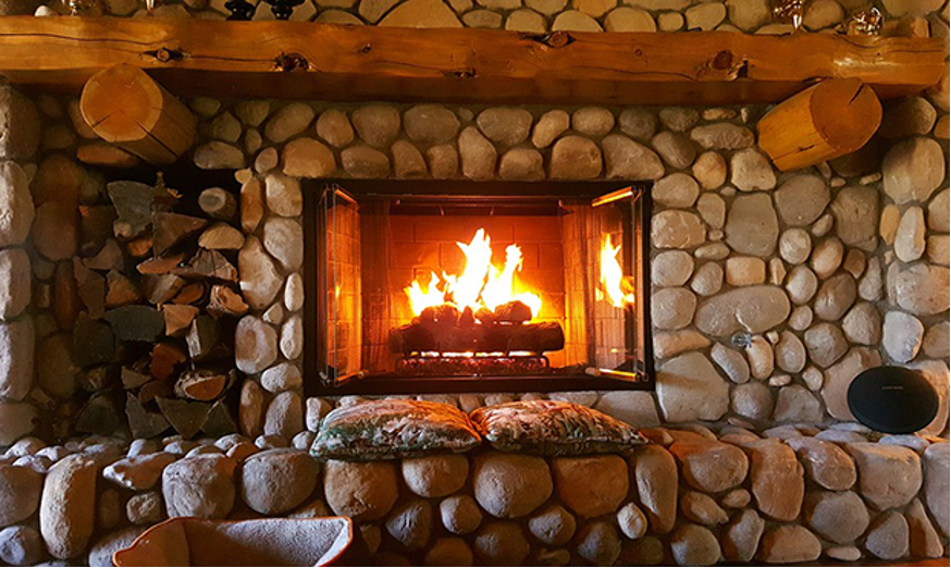 target your warmth with a fireplace: a massive rustic fireplace and surround made from river stones
