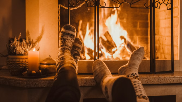 cozy socks in feet in front of a roaring fireplace