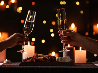 toasting champagne glasses over romantic Valentine's Day dinner at the lake