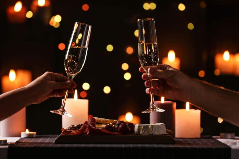 toasting champagne glasses over romantic Valentine's Day dinner at the lake
