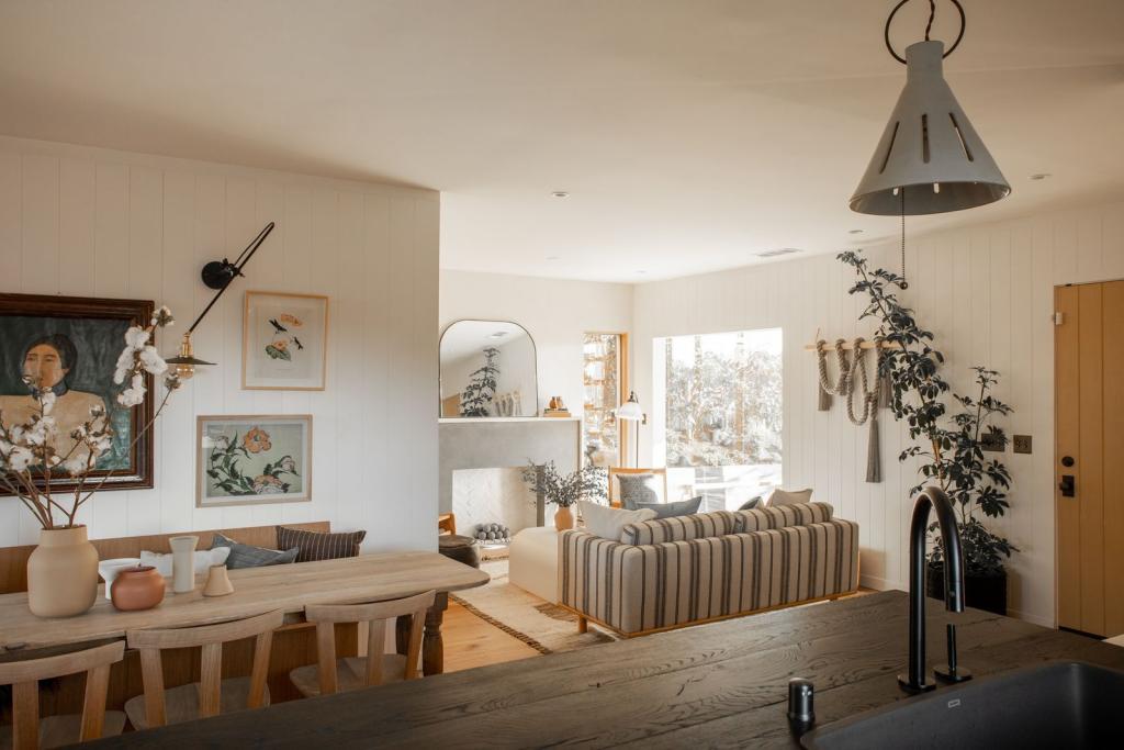 Japandi style elements depicted in the home with natural woods, shapes, metals, artwork, ceramics, connection to the outdoors in lake environment
