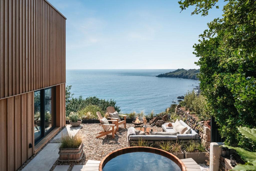 Japandi-style outdoor living space by the water with teak hot tub