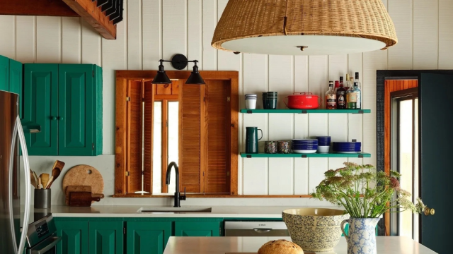 lake home kitchen with green cabinetry and an accent wall with floating shelves